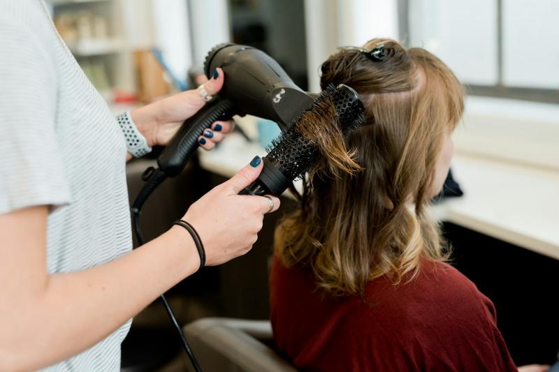 Stylist blow-drying a client's hair